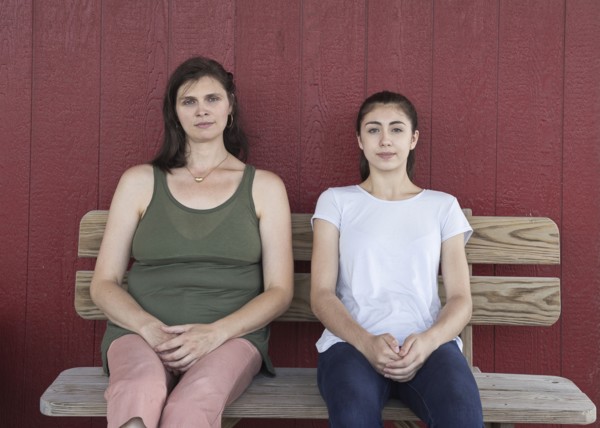 Portrait of serious Caucasian girl and mother on bench