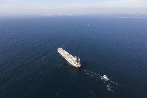 Oil tanker with tugboat at sea