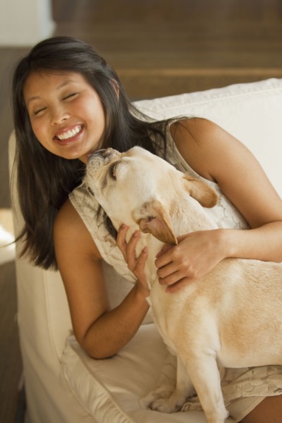 Dog licking Asian woman