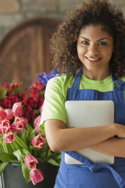 Mixed race florist holding digital tablet