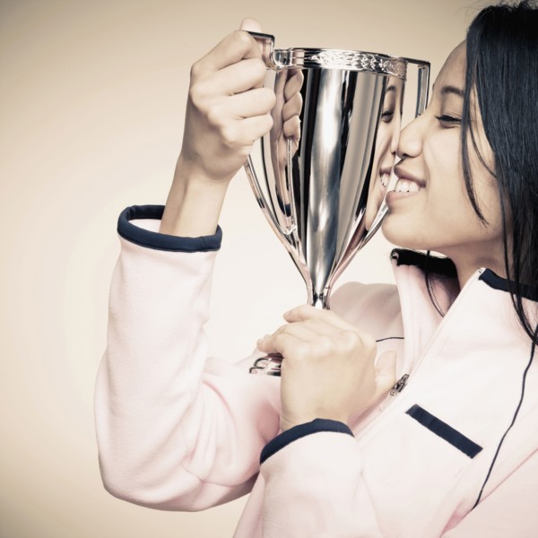 Mixed race woman holding trophy