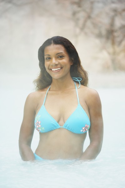 African woman standing in hot tub