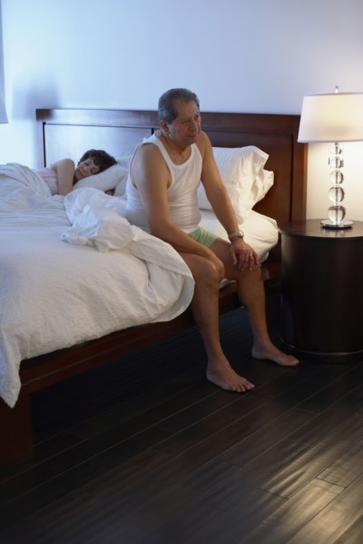 Man in bedroom waking up in the morning
