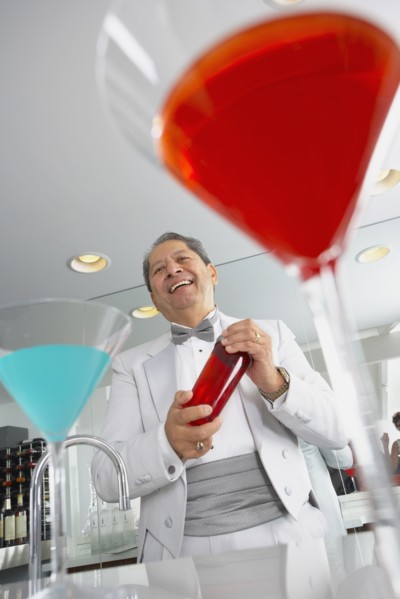 Hispanic host mixing martini cocktails at party