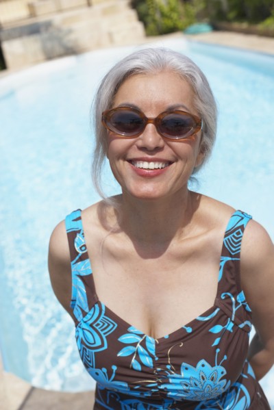 Woman at poolside in bathing suit and sunglasses