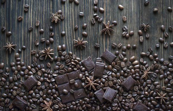 Cocoa beans and chocolate bars on wooden table