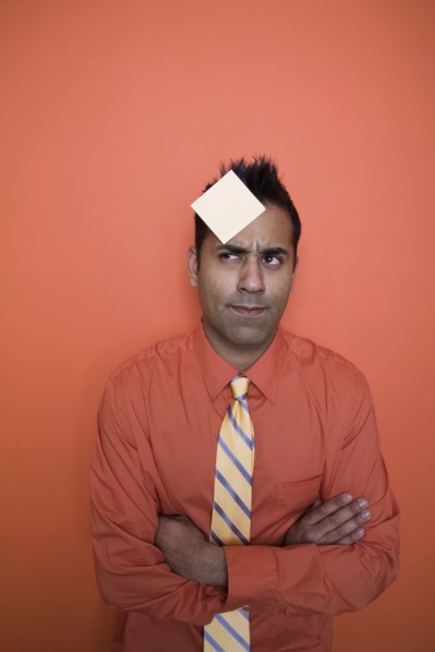 Mixed race businessman with sticky note on forehead