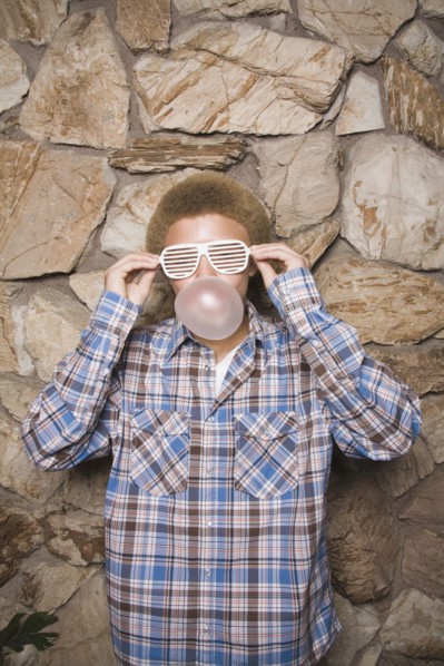 Mixed race boy in sunglasses chewing bubble gum