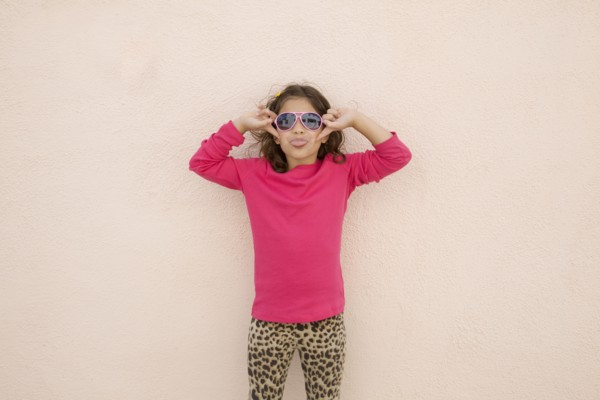Hispanic girl wearing sunglasses and sticking out tongue