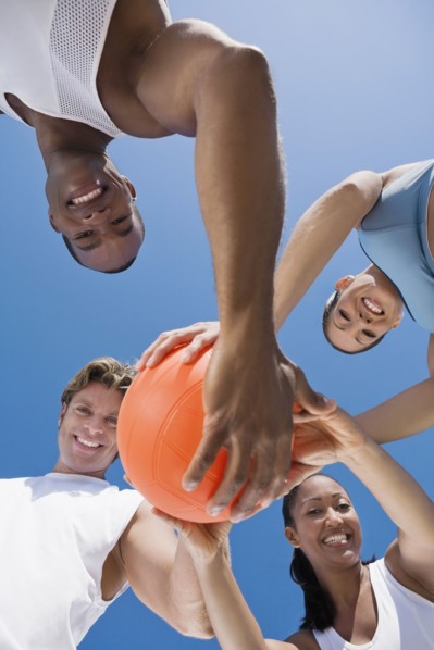 Multi-ethnic friends holding volleyball