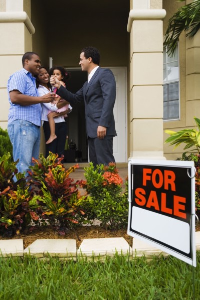 Hispanic real estate agent giving house keys to African family