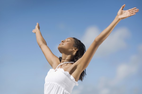 Hispanic woman with arms raised