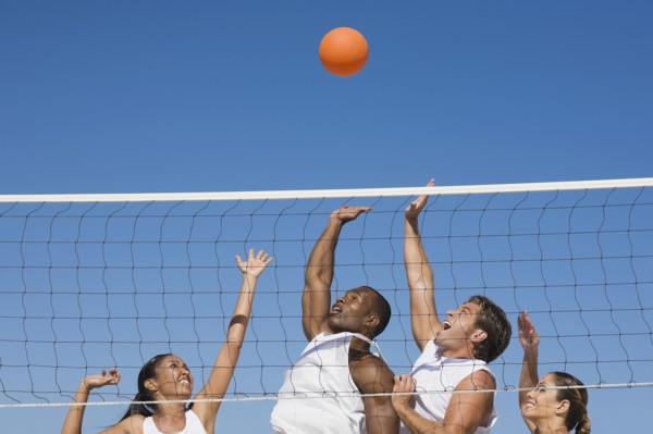Multi-ethnic friends playing volleyball