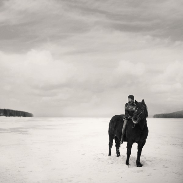 Caucasian girl riding horse in snowy field