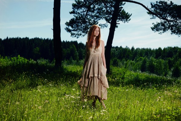 Caucasian woman standing in grass on rural hill