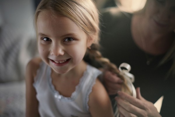Mother braiding hair of daughter