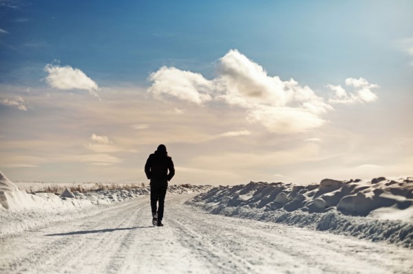 Caucasian man walking in snowy landscape