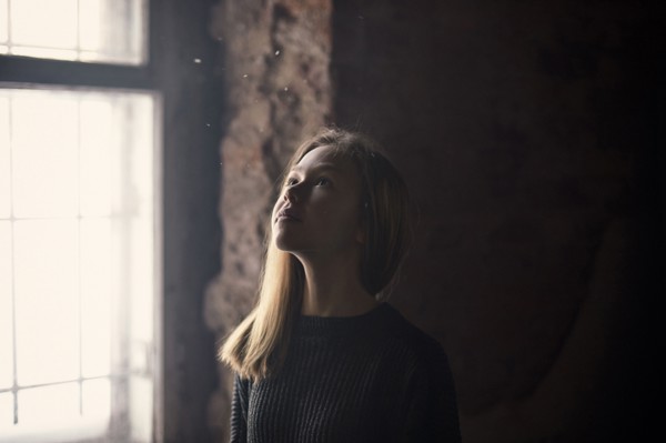 Caucasian girl standing at window