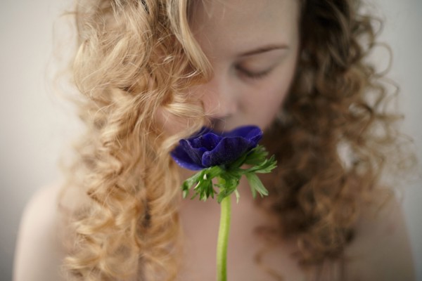Caucasian teenage girl smelling flower