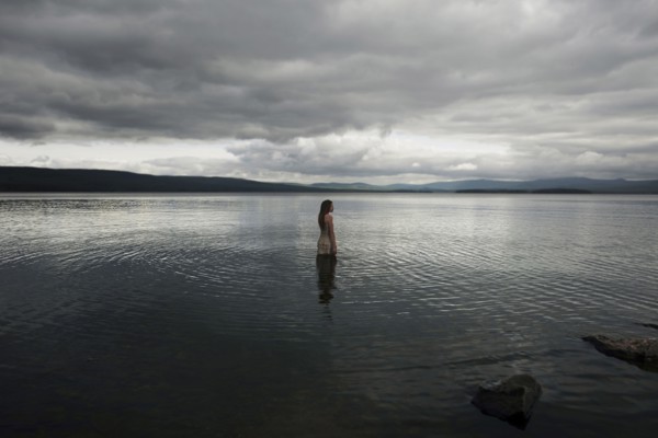 Caucasian girl wading in lake