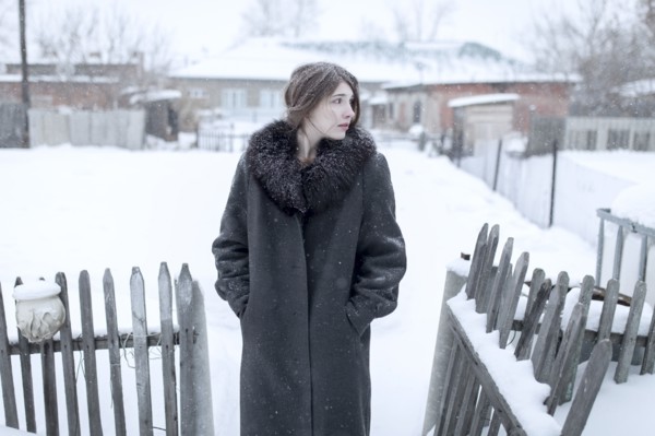 Caucasian woman wearing coat in winter near fence