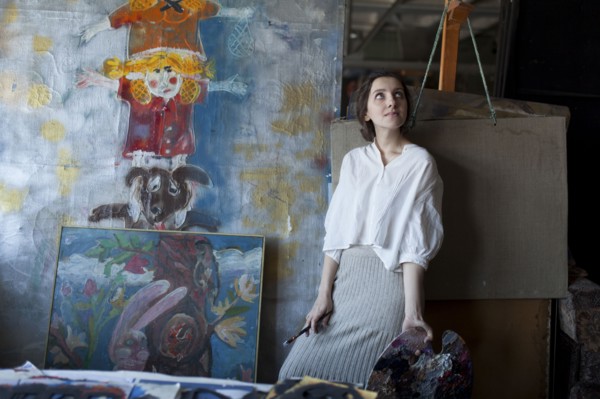 Caucasian artist holding paintbrush and palette