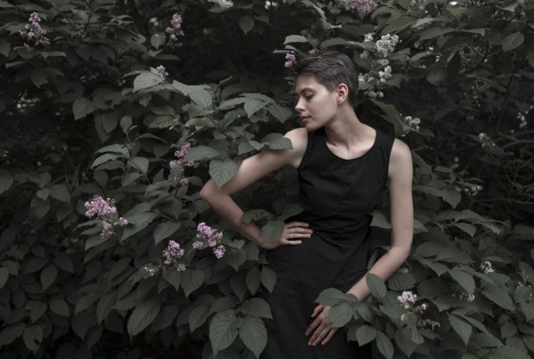 Caucasian woman near flowering tree with hand on hip