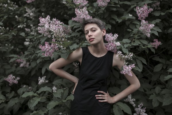 Caucasian woman near flowering tree with hands on hips
