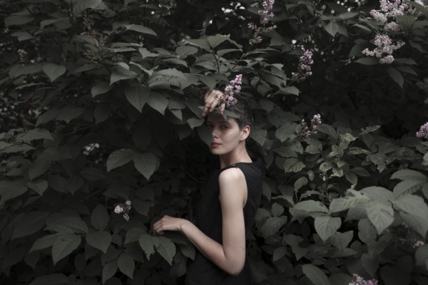 Shy Caucasian woman standing in flowering tree