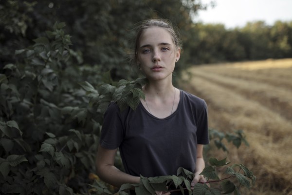 Portrait of Caucasian teenage girl holding branch