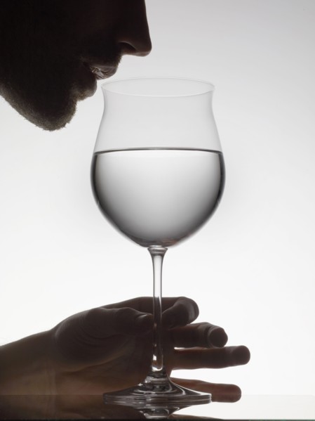 Man drinking water from wine glass