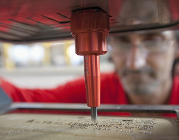 Caucasian worker using branding machine in factory