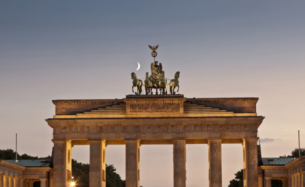 Columned building and statue lit up at night
