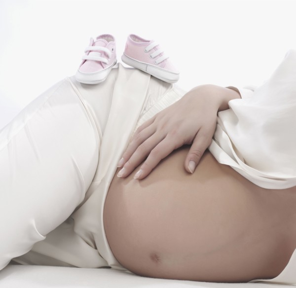 Caucasian woman holding pregnant belly