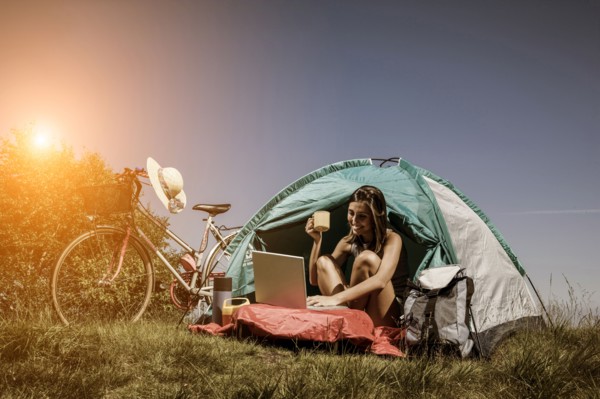 Woman using laptop in camping tent