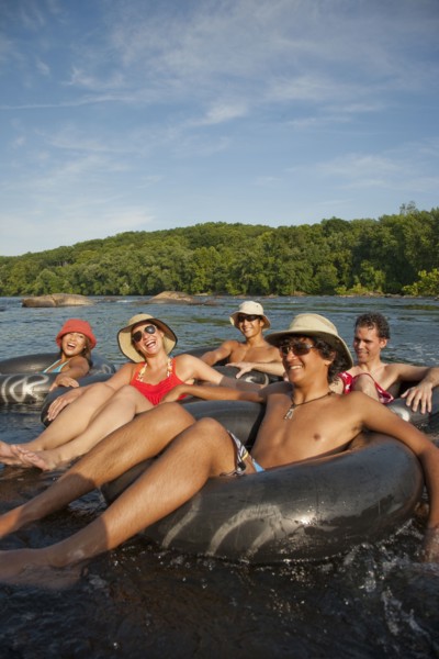 Friends floating on river in inner tubes