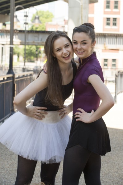 Portrait of smiling Caucasian ballerinas standing outdoors