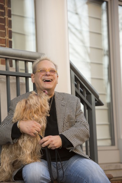 Portrait of Caucasian man sitting on stoop holding dog