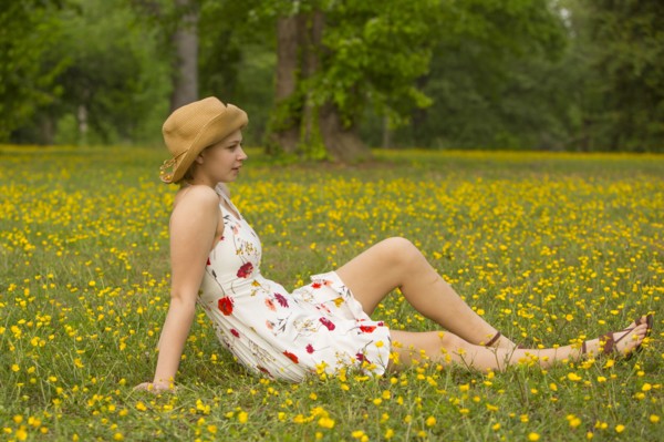 Caucasian teenage girl sitting in field of flowers