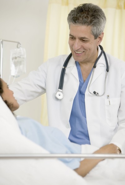 Male doctor talking to female patient in hospital