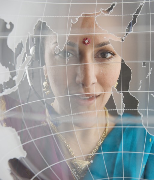 Woman in traditional Indian dress behind globe