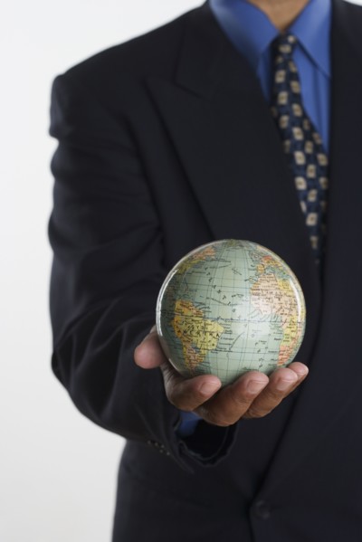 Mid section of businessman holding globe in hand