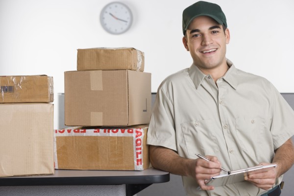 Portrait of delivery man with stack of boxes