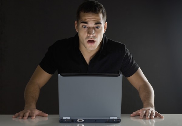 Man surprised while looking at laptop