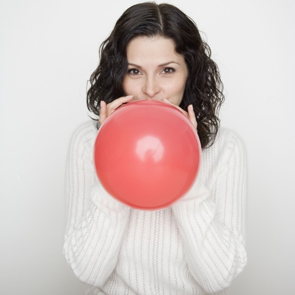 Portrait of woman blowing up balloon
