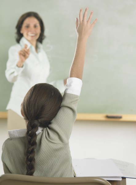 Young girl raising her hand in class