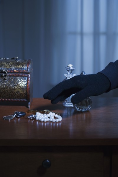 Thief reaching for a string of pearls