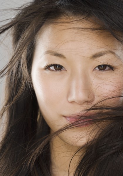 Close up of young Asian woman with hair in face