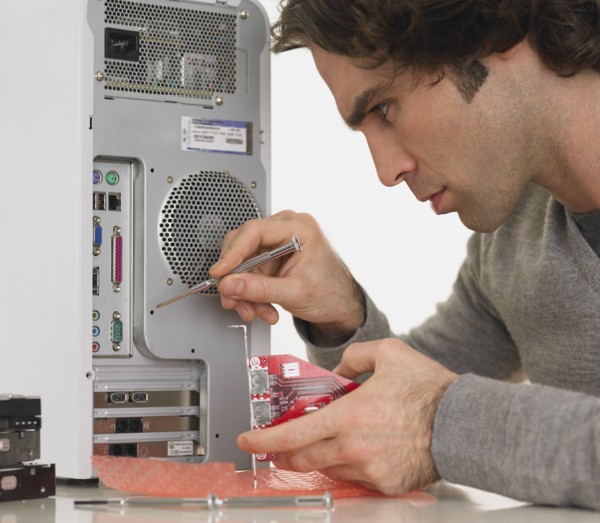 Hispanic man fixing computer