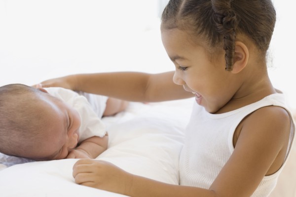 African girl smiling at baby sibling